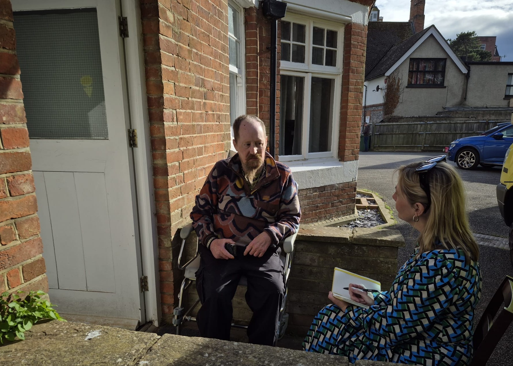 Support worker meeting a resident outside a home